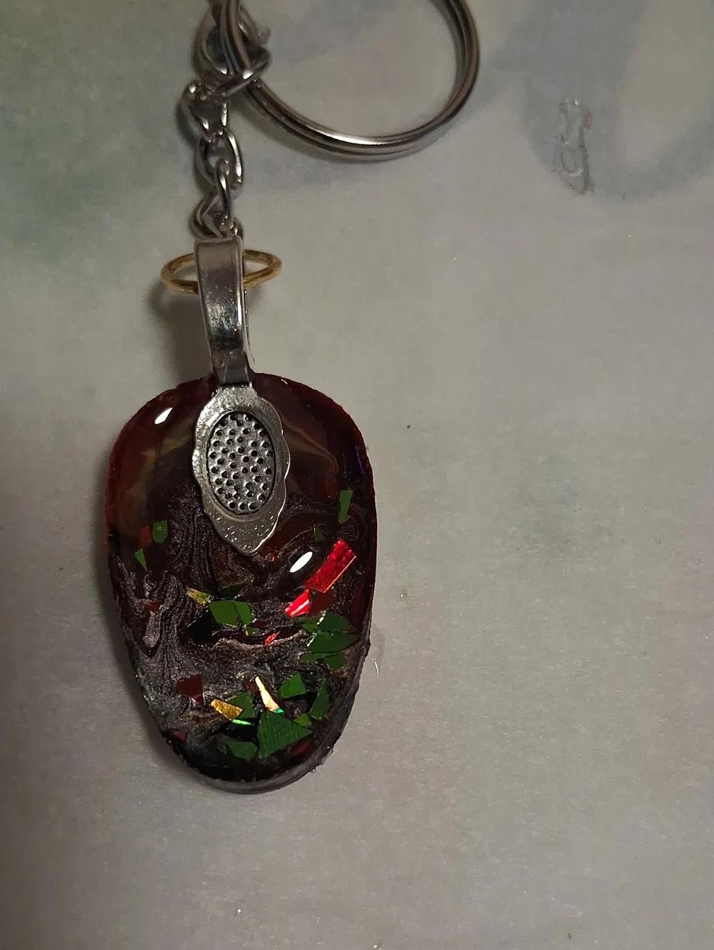 Artisan Bronze Mask Keychain with Green Crystal Accent